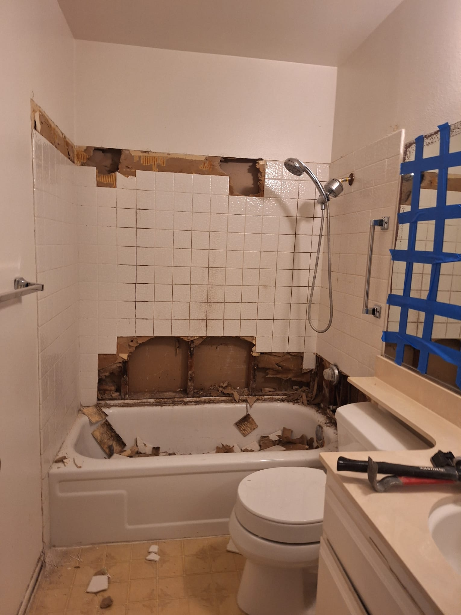 Bathroom with tub surround tile and drywall removed during demolition